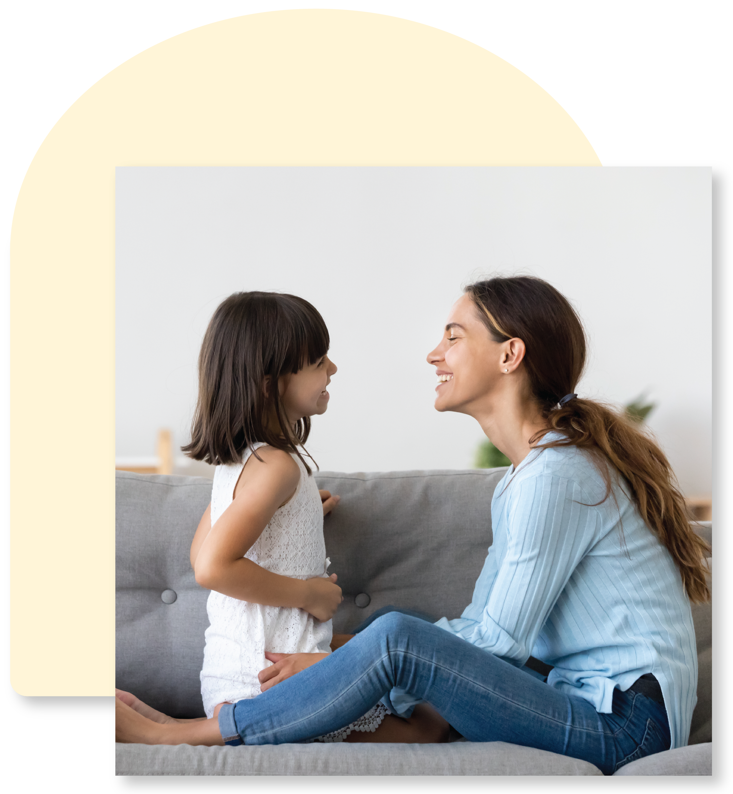 mother and daughter laughing together on sofa